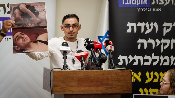 ברסלבסקי אוחז בתמונתו מהשבי, היום (צילום: שלו שלום) רום ברסלבסקי במסיבת עיתונאים של מועצת אוקטובר בכנסת לקראת פתיחת המושב האחרון של הכנסת ה-25