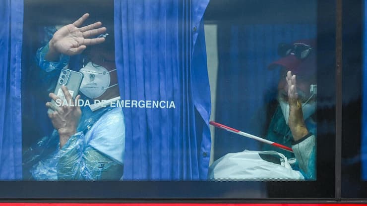 הנוסעים באוטובוס בדרך למטוסים (צילום: JORGE GUERRERO / AFP) פינוי אוניית הקרוז ההולנדית MV Hondius בטנריף שבאיים הקנריים, לאחר התפרצות נגיף האנטה