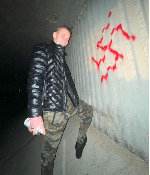 מיכאיל צ'יקווישווילי ליד צלב קרס שריסס