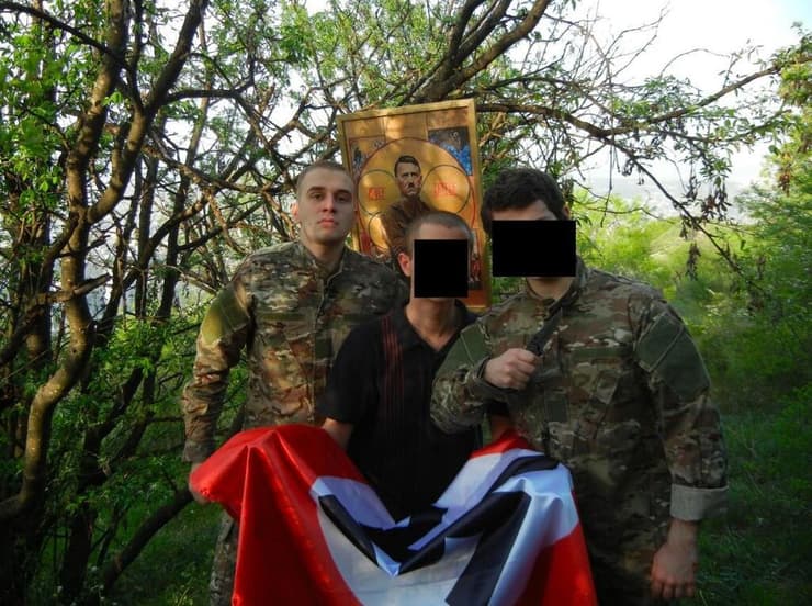 מיכאיל צ'יקווישווילי ליד תמונה של היטלר ודגל נאצי