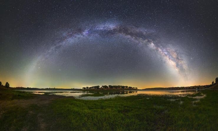 קשת שביל החלב מעל אגם (צילום: Science Photo Library/Reuters) קשת שביל החלב מעל אגם