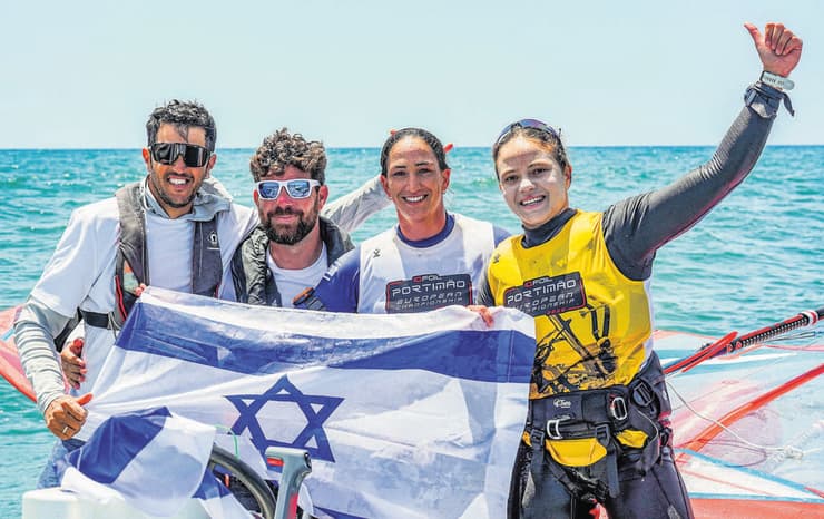 שחר צוברי (ראשון משמאל) (Sailing Energy) המדליסטיות עם עוזר המאמן עודד אשר והמאמן שחר צוברי
