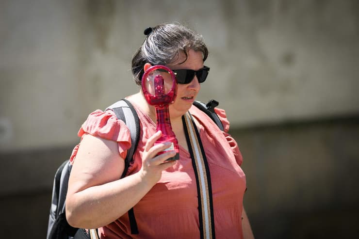 תושבת נאנט נעזרת במאוורר נייד כדי ליהנות ממעט רוח (צילום: Loic VENANCE / AFP) גל חום אירופה צרפת נאנט מאוורר נייד