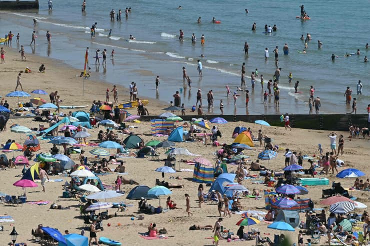 מנסים להתקרר בחוף הים של אנגליה (צילום: JUSTIN TALLIS / AFP) גל חום אירופה בריטניה חוף אנגליה