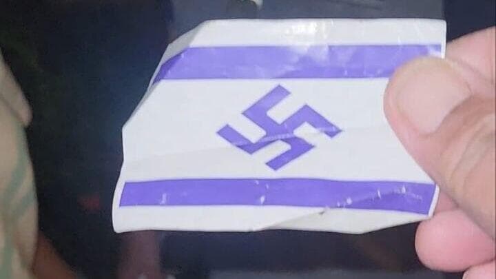 דגל ישראל עם צלב קרס שחולק למתפרעים בבית סולברג דגל ישראל עם צלב קרס חולק למפגינים במחאה על חוק הגיוס מחוץ לביתו של שופט העליון סולברג