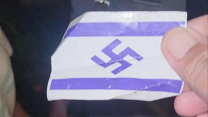 הדגל שחולק למפגינים החרדים דגל ישראל עם צלב קרס חולק למפגינים במחאה על חוק הגיוס מחוץ לביתו של שופט העליון סולברג