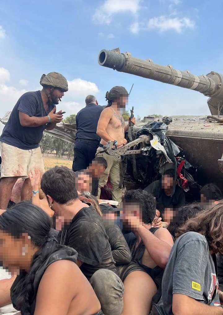 "מסתובבים בינינו אלפי אנשים שקופים". דניאל לצד אחרים בצמוד לטנק ששימש מחסה (צילום: באדיבות המצולם) דניאל שרעבי, ב-7 באוקטובר ליד הטנק שלידו נלחם עם אחיו נריה שרעבי