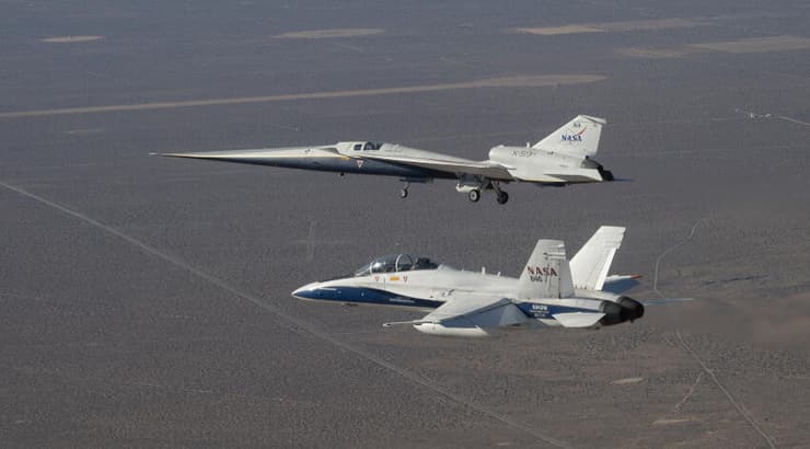 עיצוב ייחודי. מטוס X-59 (רחוק מהמצלמה) עם מטוס F-18 שמלווה אותו לצרכי מחקר בטיסת הבכורה של ה-X-59 באוקטובר 2025 (צילום: NASA / Jim Ross) עיצוב ייחודי. מטוס X-59 (רחוק מהמצלמה) עם מטוס F-18 שמלווה אותו לצרכי מחקר בטיסת הבכורה של ה-X-59 באוקטובר 2025