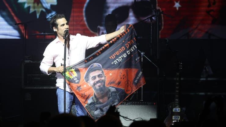 עצוב ומרגש. אביב גפן מניף כרזה שעליה נהוראי לייזר ז"ל על הבמה בפתאל רוק (צילום: עזרא לוי) אביב גפן בפתאל רוק