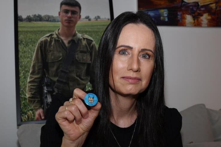 נורית, אימו של עדי ליאון ז"ל, עם הסיכה לזכרו (צילום: יריב כץ) נורית לאון והסיכה שעוצבה עם הציור שצייר בנה, עדי ז"ל