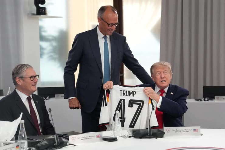 טראמפ מקבל חולצת כדורגל עם המספר 47 - מספרו כנשיא ארה"ב - מקנצלר גרמניה פרידריך מרץ, בפסגת G7 בצרפת (צילום: Camus/Pool via REUTERS) אוויאן צרפת פסגת מנהיגי פורום G7