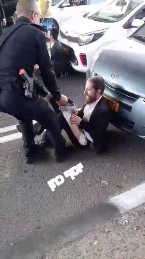 מפקד תחנת בני ברק-רמת גן סנ"צ יובל שביט קורע את מכנסיו של מפגין חרדי