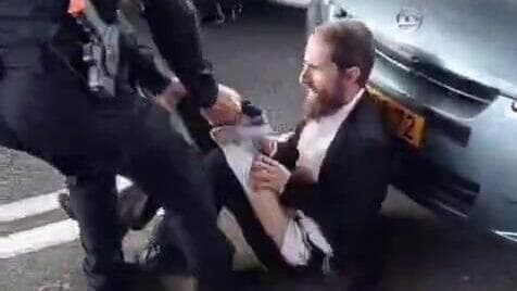 קריעת מכנסיו של אחד המוחים (צילום: יוסף כהן, שימוש לפי סעיף 27א' בחוק זכויות יוצרים) קורע למפגין את מכנסיו
