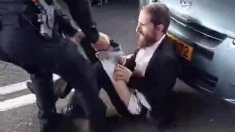 קריעת מכנסיו של אחד המוחים (צילום: יוסף כהן, שימוש לפי סעיף 27א' בחוק זכויות יוצרים) קורע למפגין את מכנסיו