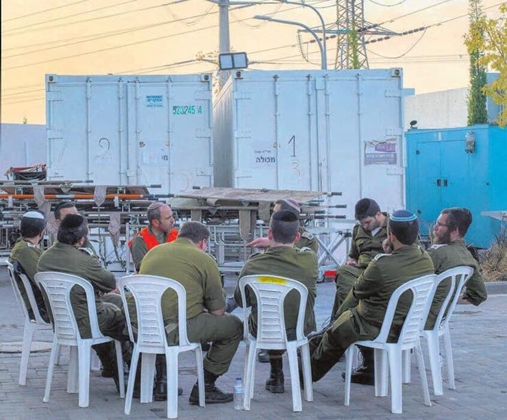 מעגל שיח של אנשי הרבנות הצבאית בכניסה למאנ"ח במחנה שׁוּרָה, 31.10.23 (צילום: יובל חן) מעגל שיח של אנשי הרבנות הצבאית בכניסה למאנ"ח במחנה שורה, 31.10.23