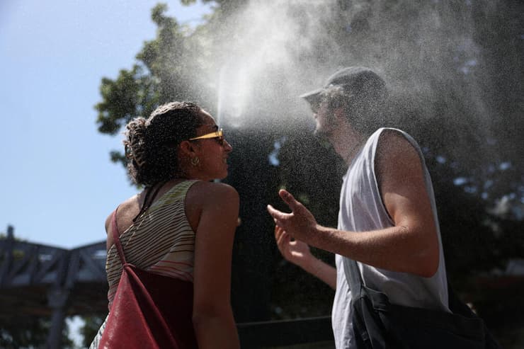 מנסים להצטנן בבירה הצרפתית (צילום: REUTERS/Alice Sacco) אירופה גל חום צרפת פריז