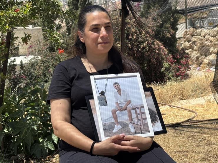"לוקחת לעצמי להסתכל על החיים האלה בעיניים של נוה". עינב חבשוש עם תמונת בנה (צילום: גיל יוחנן ) עינב חבשוש