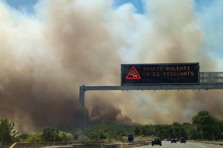 עשן מיתמר מעל הכביש בנים, דרום צרפת, היום בצהריים (צילום: Agnès PEDRERO / AFP) אירופה צרפת מזג אוויר שריפה ליד נים