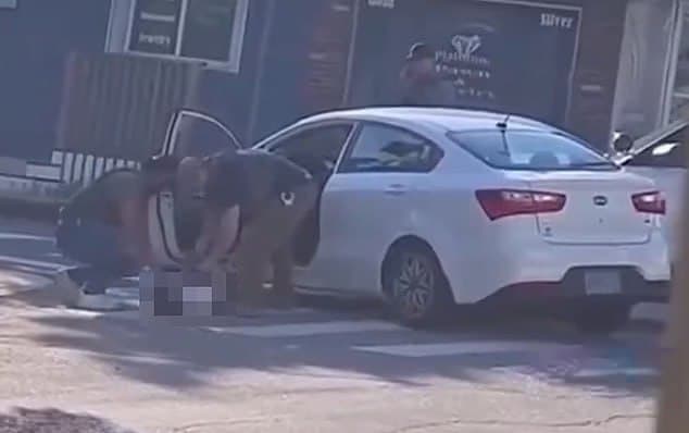 הסוכנים מתועדים מוציאים את גופתו של גררו מהרכב ארה"ב הרכב שבו נורה חואן סבסטיאן גררו על ידי ICE