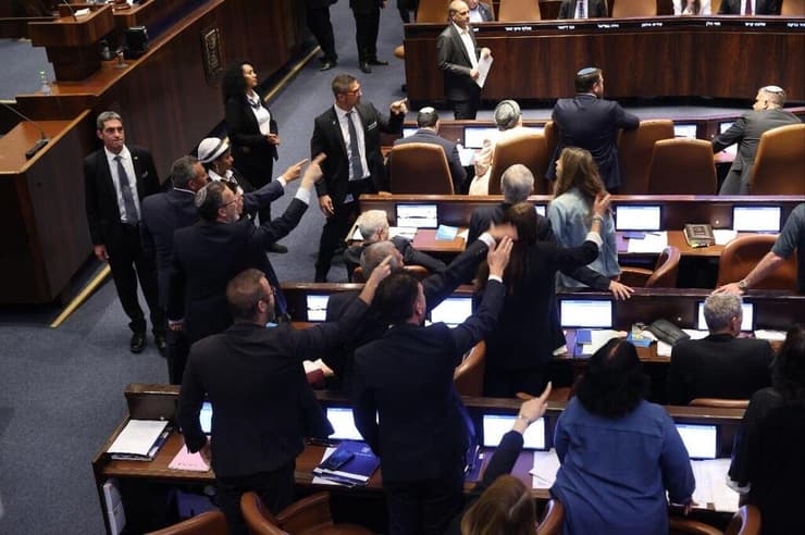 הח"כים מהאופוזיציה מוחים בזמן ההצבעה (צילום: אלכס קולומויסקי) הצבעה לחוק שירות ביטחון במליאת הכנסת