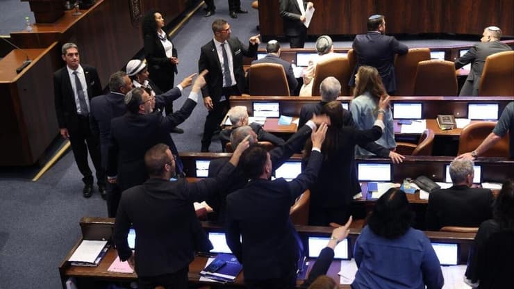 ח"כים מהאופוזיציה מוחים בזמן ההצבעה על החוק
(צילום: אלכס קולומויסקי ) הצבעה לחוק שירות ביטחון במליאת הכנסת