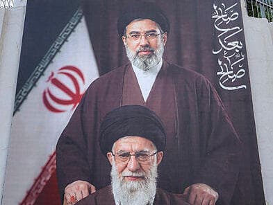 גשר אחד רחוק מידי (צילום: AHMAD AL-RUBAYE / AFP) תמונה של מוג'תבא ועלי חמינאי שצולמה מחוץ לשגרירות ארה"ב בבגדד עיראק