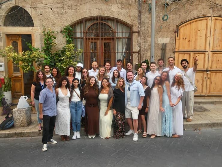 משתתפי תוכנית Storytellers של תגלית ישראל מצטלמים לתמונה קבוצתית ביפו במהלך סיור לימודי ברחבי ישראל (צילום: באדיבות תגלית ישראל) Participants in Birthright Israel’s Storytellers program pose for a group photo in Jaffa during an educational tour across Israel
