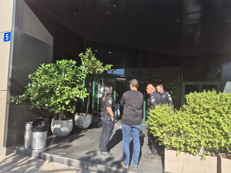 כוחות המשטרה ליד דלת הכניסה המנופצת בכניסה למערכת חדשות 12
