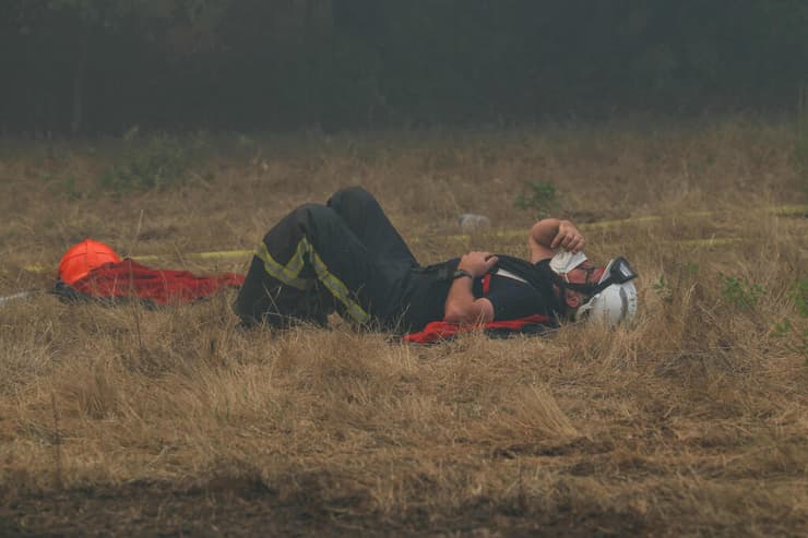 אחד מהם נצפה נח על הקרקע, עם מסכה (צילום: Alain JOCARD / AFP) שריפה מחוז ז'ירונד צרפת