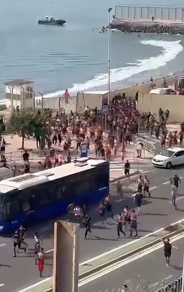 פורצים את הגדר לתוך סאוטה ורצים באושר לתוך השטח הספרדי, היום מרוקו ספרד פריצה המונית של מהגרים ל סאוטה דרך הים