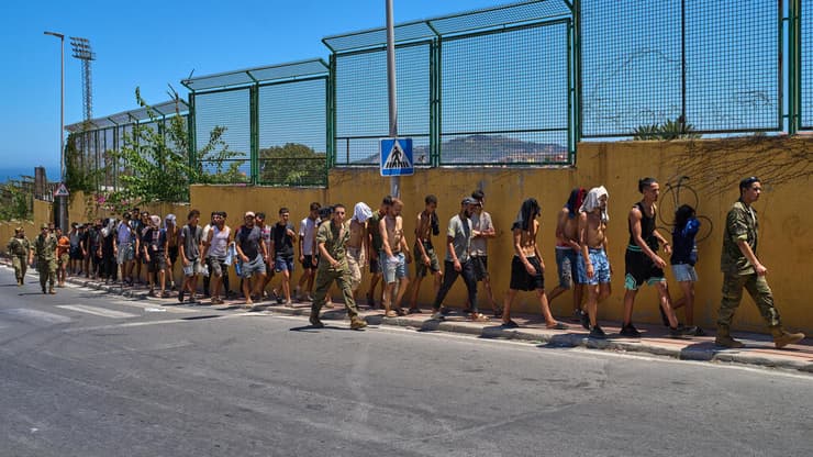 מהגרים מלווים על ידי כוחות הביטחון הספרדיים בחזרה לגבול, היום (צילום: AP Photo/Bernat Armangue) מהגרים שחצו מ מרוקו חוזרים לארצם מ סאוטה, ספרד