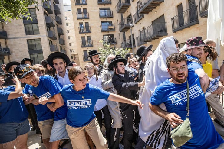 פעילי מפלגת הדמוקרטים מנסים למנוע ממפגינים חרדים לפרוץ לבית הקפה (צילום: אלכס קולומויסקי) פעילי מפלגת הדמוקרטים מנסים למנוע ממפגינים חרדים לפרוץ לבית הקפה "בסמטה"
