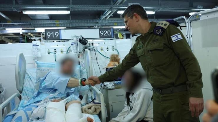 אל"מ ד"ר אבי שינה, מפקד המרכז לשירותי רפואה בצה"ל, עם אחד הפצועים (צילום: דובר צה"ל) אל"מ ד"ר אבי שינה, מפקד המרכז לשירותי רפואה בצה"ל
