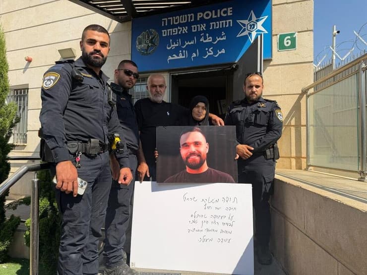 משפחת מחאמיד עם השוטרים ותמונת הבן המנוח (צילום: חסן שעלאן ) משפחתו של הנרצח מוחמד מחמוד מחאמיד מאום אל פאחם הגיעו להודות לקצין המבצעים ראמז עראם ממשטרת אום אל פאחם על פיענוח הרצח
