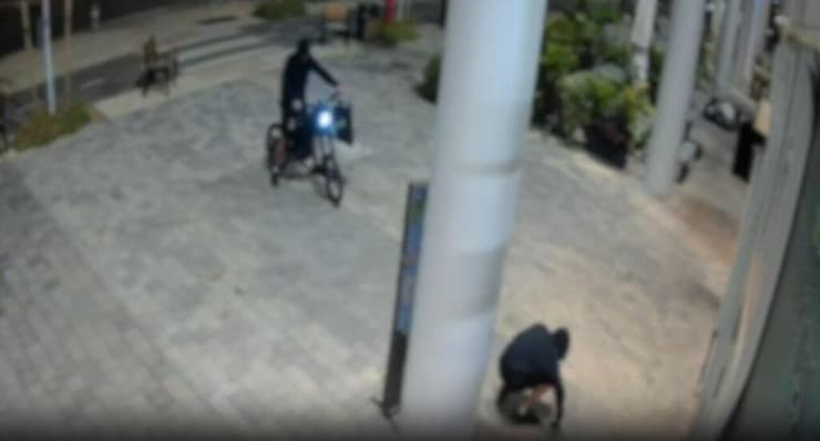 אחד החשודים מרים את הרימון אחרי שלא התפוצץ תיעוד: השלכת רימון לעבר סניף ג׳אפניקה בקריית אונו