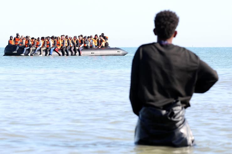 צילום: Francois LO PRESTI / AFP מהגרים על סירה סמוך לחופי צרפת ב תעלת למאנש בדרך ל אנגליה בריטניה 29 ביולי