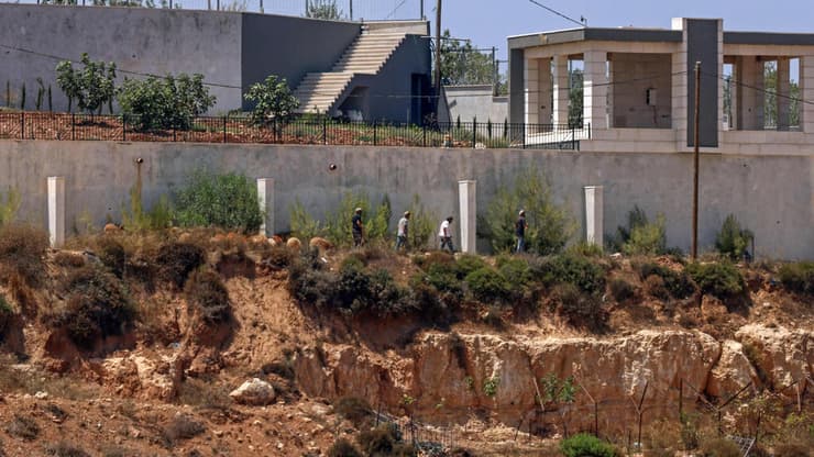 קוסרה (צילום: Zain JAAFAR / AFP) מתנחלים מול בתי פלסטינים בכפר קוסרה