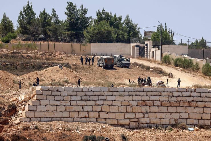צילום: Zain JAAFAR / AFP כוחות צה"ל לצד מתנחלים מול בתי פלסטינים בכפר קוסרה