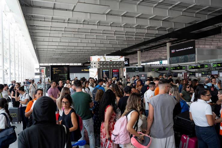 נוסעים מחכים בתור בנמל התעופה של קטניה. שער הכניסה לסיציליה - והחמישי ברשימת נמלי התעופה העמוסים של איטליה (צילום: Marco Restivo/Etna Walk/via REUTERS) איטליה סיציליה התפרצות הר הגעש אטנה אתנה נמל התעופה ב קטניה