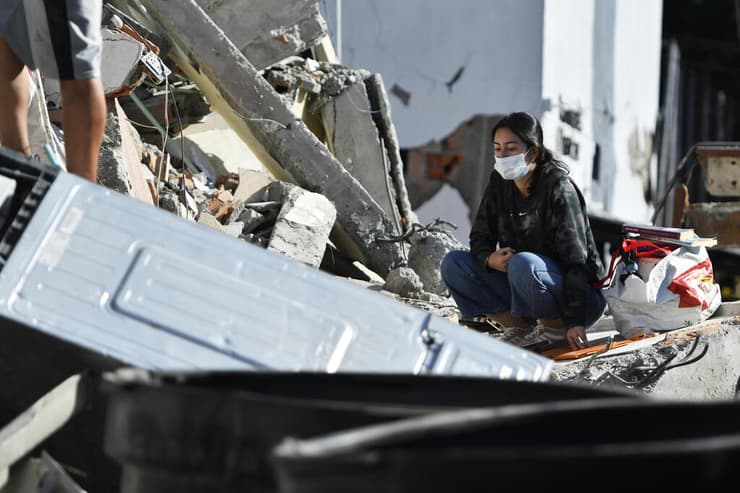 אישה שהגיעה לחפש חפצים אישיים בהריסות בית נחה על השברים (צילום: Gabriel Aponte/Getty Images) קולומביה רעידת אדמה רעש הריסות פריירה ניצולה שהגיעה לחפש חפצים אישיים בבית שקרס