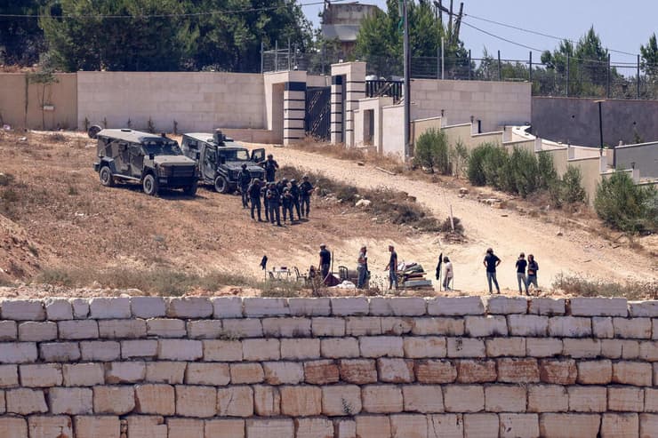 צילום: Zain JAAFAR / AFP כוחות צה"ל לצד מתנחלים מול בתי פלסטינים בכפר קוסרה