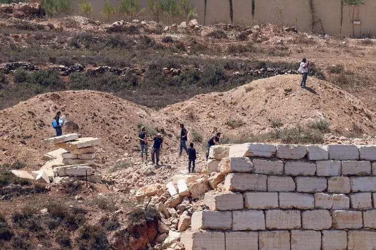 מתנחלים מול בתי פלסטינים בכפר קוסרה (צילום: Zain JAAFAR / AFP) מתנחלים מול בתי פלסטינים בכפר קוסרה
