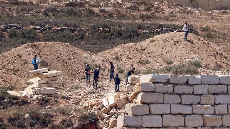 מתנחלים מול בתי פלסטינים בכפר קוסרה (צילום: Zain JAAFAR / AFP) מתנחלים מול בתי פלסטינים בכפר קוסרה