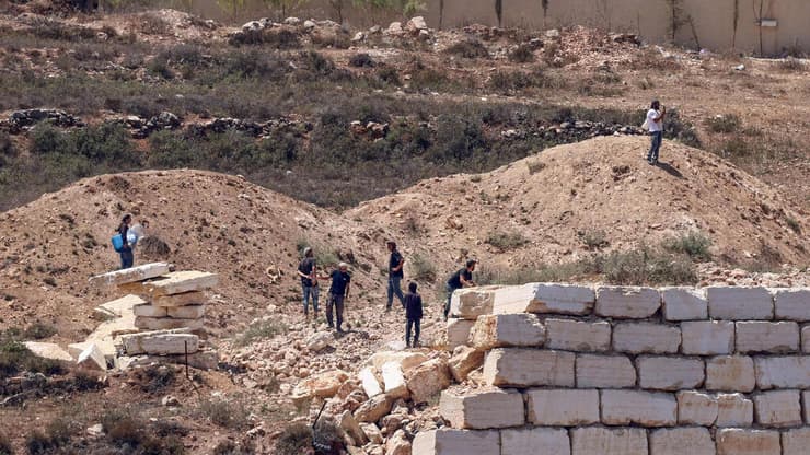 "המתנחלים מנתקים את המים והחשמל" (צילום: Zain JAAFAR / AFP) מתנחלים מול בתי פלסטינים בכפר קוסרה