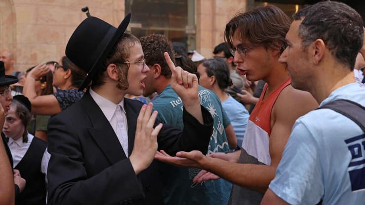 "החלטה קשה וכואבת שנעשתה מתוך אחריות" (צילום: AHMAD GHARABLI / AFP) הפגנת חרדים מול קפה בסמטה בירושלים
