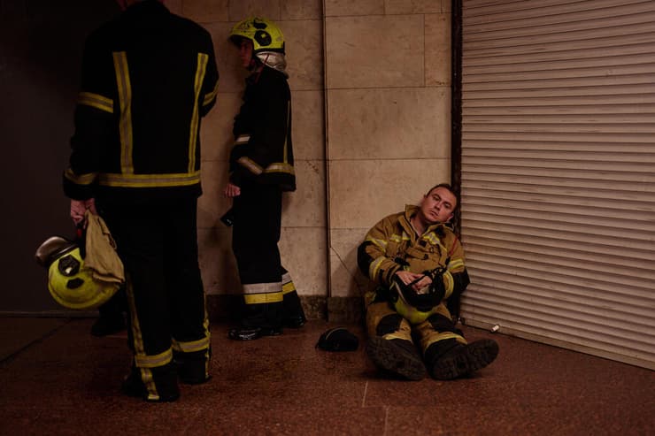 לוחמי האש האוקראינים תופסים מחסה במטרו בזמן אזעקה, הלילה (צילום: AP Photo/Francisco Seco) אוקראינה קייב אש ב יריד הספרים מתקפה של רוסיה כבאים נחים ב מטרו בזמן אזעקה