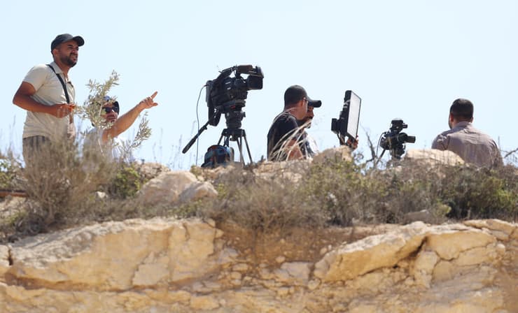 נציגי תקשורת מתצפתים על הבית הנצור בקוסרה (צילום: שאול גולן) נציגי תקשורת מתצפתים על הבית הנצור בקוסרה