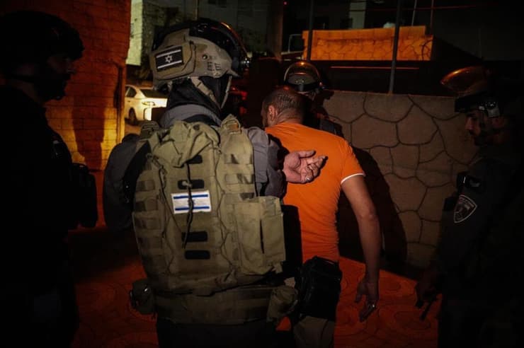 החשוד (בחולצה כתומה) מעוכב לחקירה