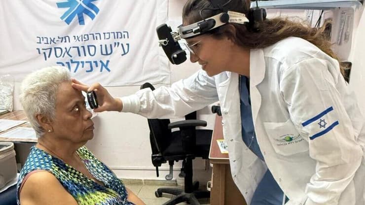 צילום: השגרירות בפנמה הבן הפארמדיק עידו בודק לחץ דם לאשת הנשיא בעוד האם ד"ר רונית אלמוג, צופה בגאווה