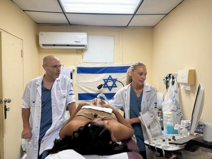 צילום: השגרירות בפנמה הבן הפארמדיק עידו בודק לחץ דם לאשת הנשיא בעוד האם ד"ר רונית אלמוג, צופה בגאווה